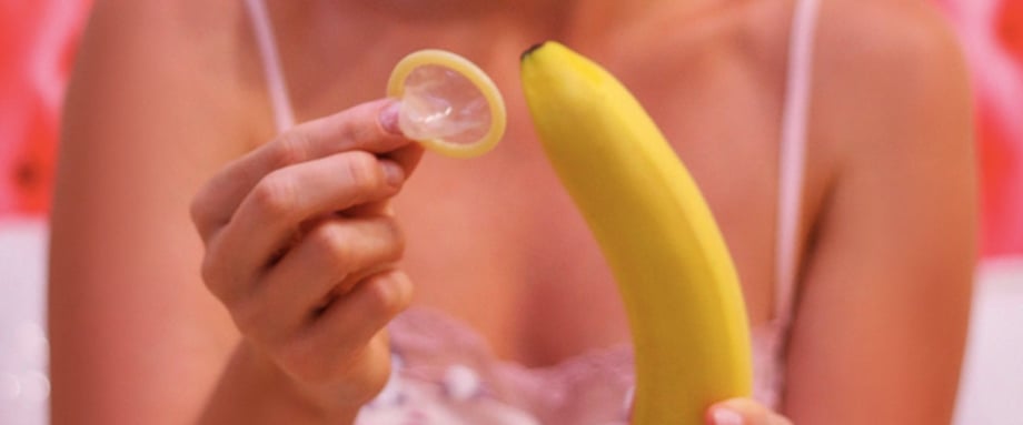 MUJER-PONIENDO-CONDON-A-BANANA-USAR-CONDONES-CÓMO-PONER-CONDÓN-PLACER-SEXUAL