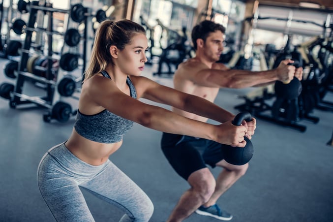 PAREJA CARGANDO MANCUERNAS EN GIMNASIO BENEFICIOS DEL EJERICICIO PARA EL SEXO